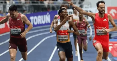Tshepiso Masalela pointing at Azeddine Habz while crossing the finish line at the 2026 ORLEN Copernicus Cup 1500m.